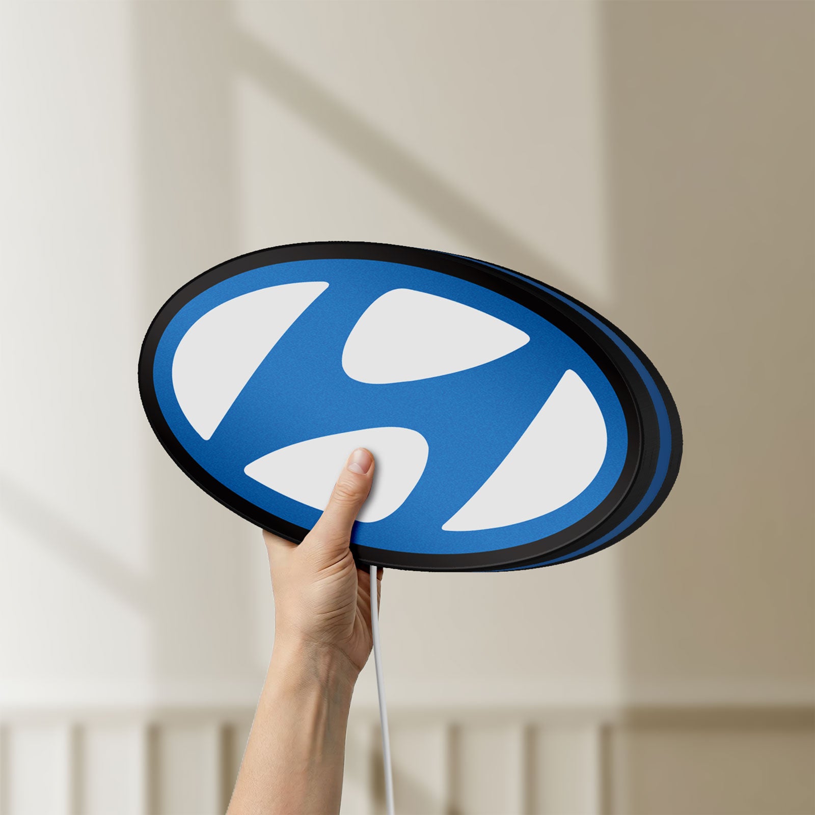 Unlit Hyundai LED lightbox held by hand to show size and details