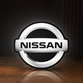 Front view of Nissan LED lightbox sign glowing on a wooden desk