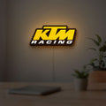 KTM Racing LED lightbox hanging on a room wall with soft yellow light