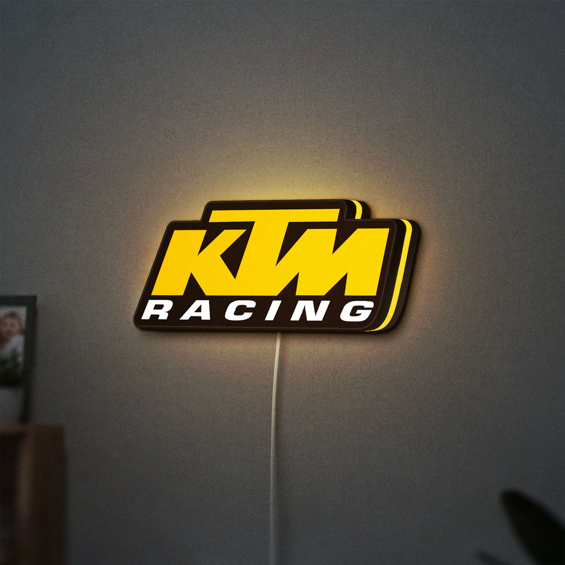 KTM Racing LED lightbox hanging on a wall with yellow glow