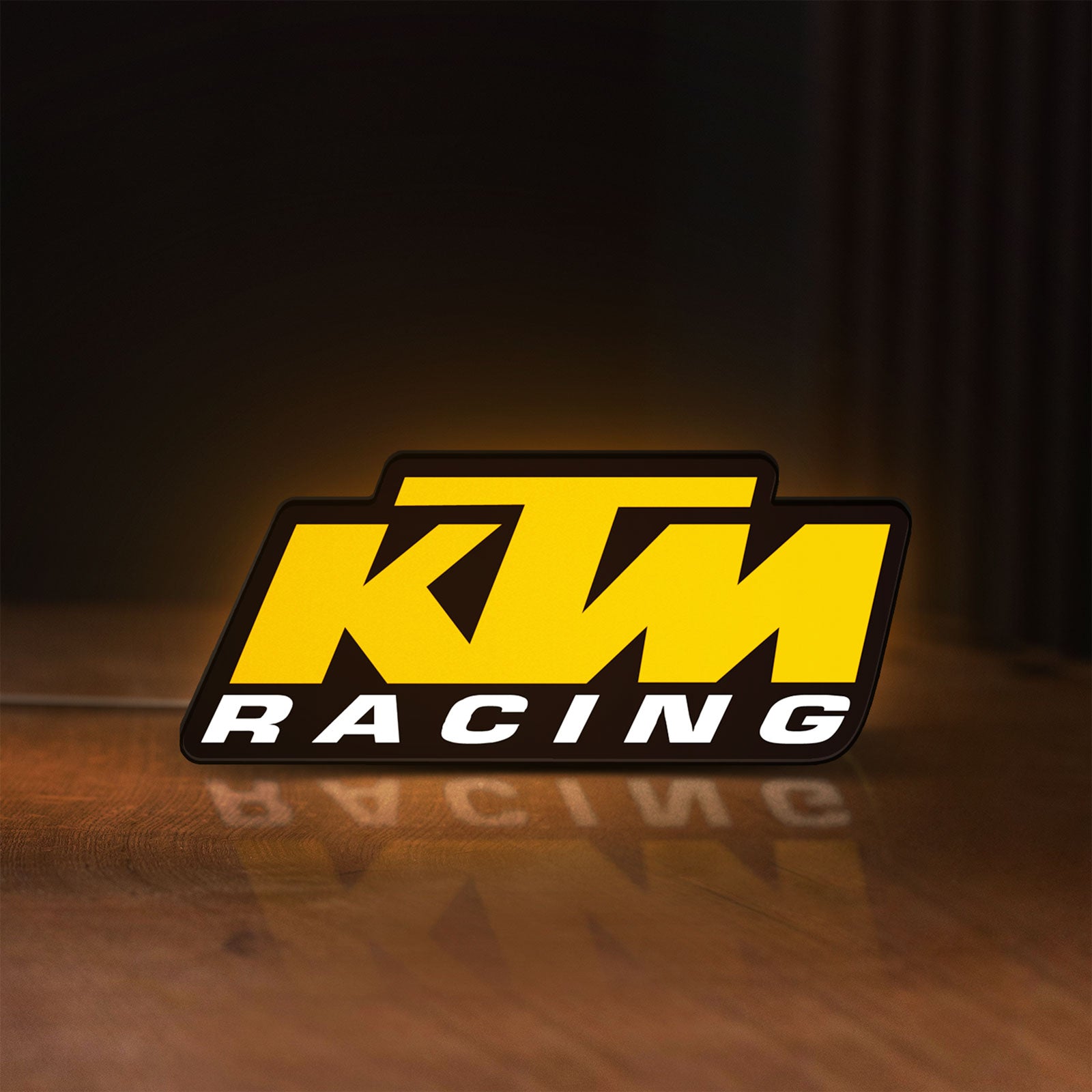 Front view of KTM Racing LED lightbox sign glowing on a wooden desk