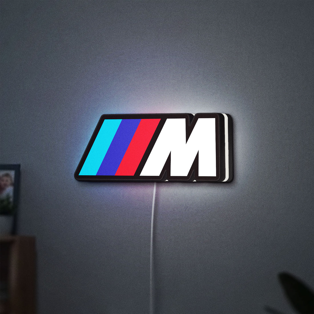BMW M LED lightbox hanging on a wall with white glow