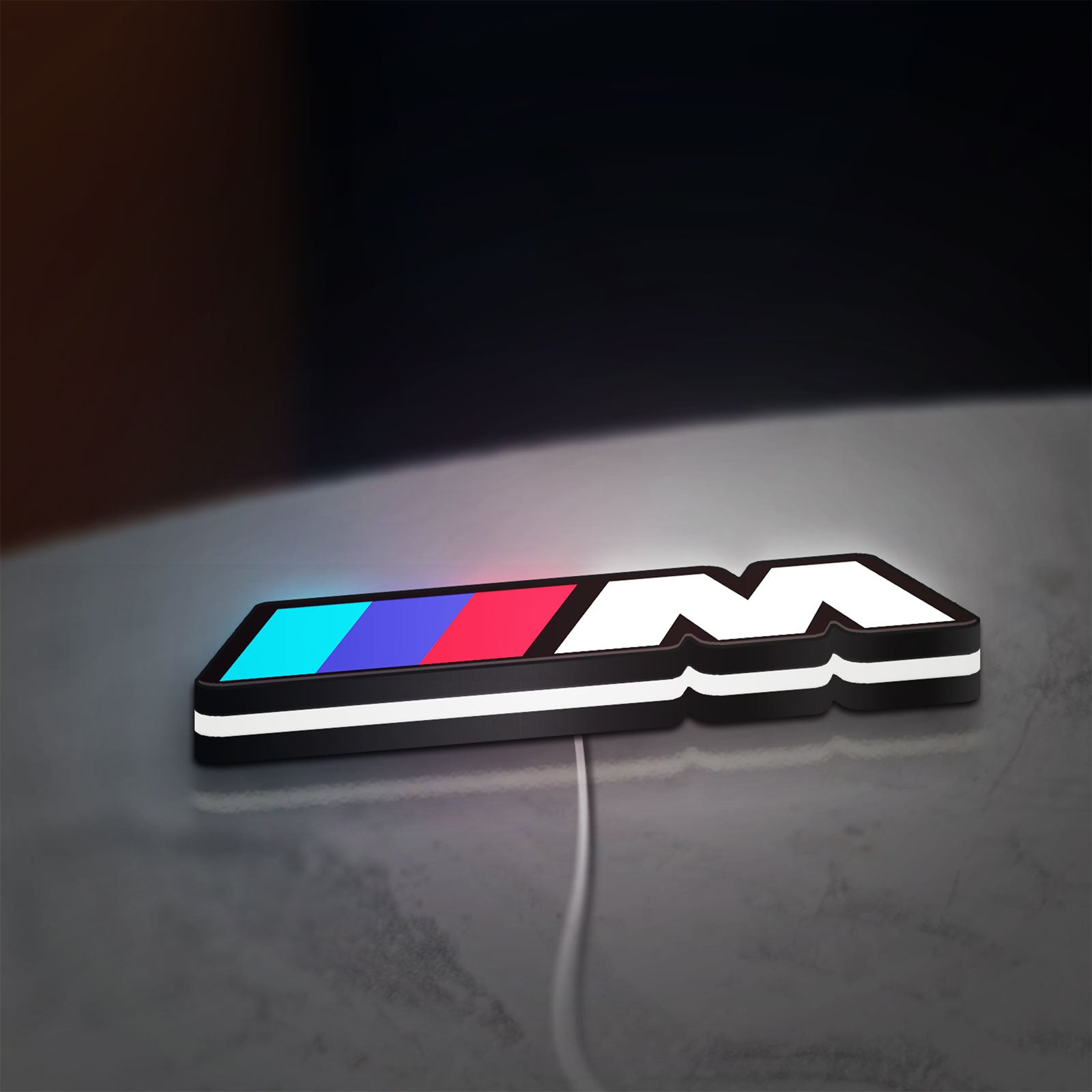 BMW M LED lightbox lying flat on a desk with white glow