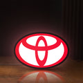 Front view of Toyota LED lightbox sign glowing on a wooden desk