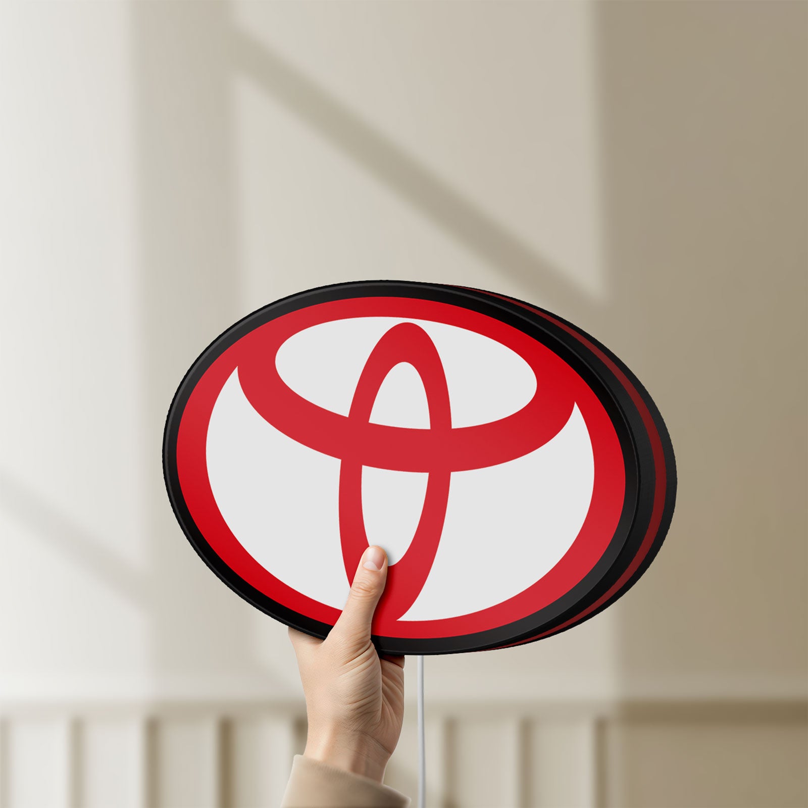 Unlit Toyota LED lightbox held by hand to show size and details