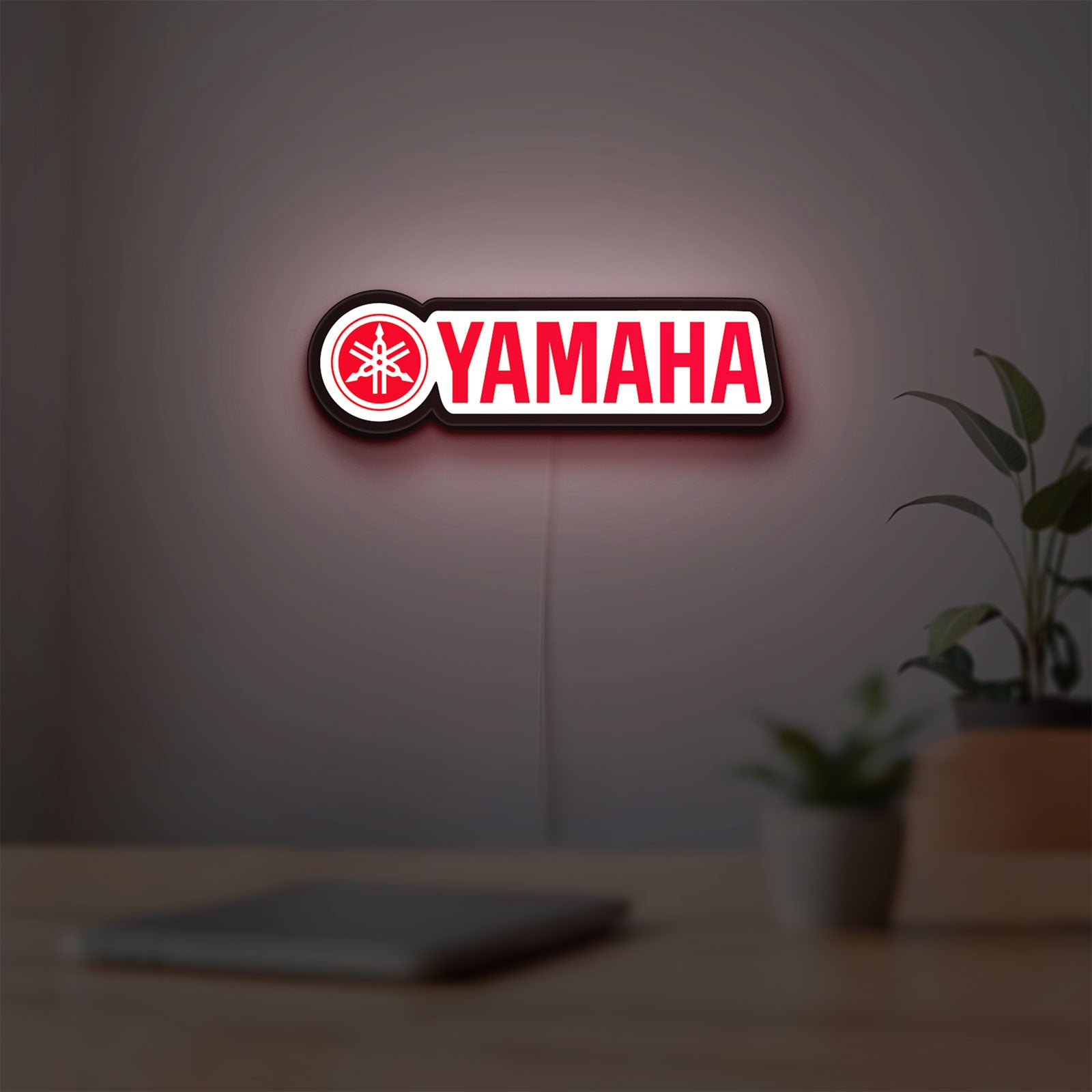 Yamaha LED lightbox hanging on a room wall with soft red light