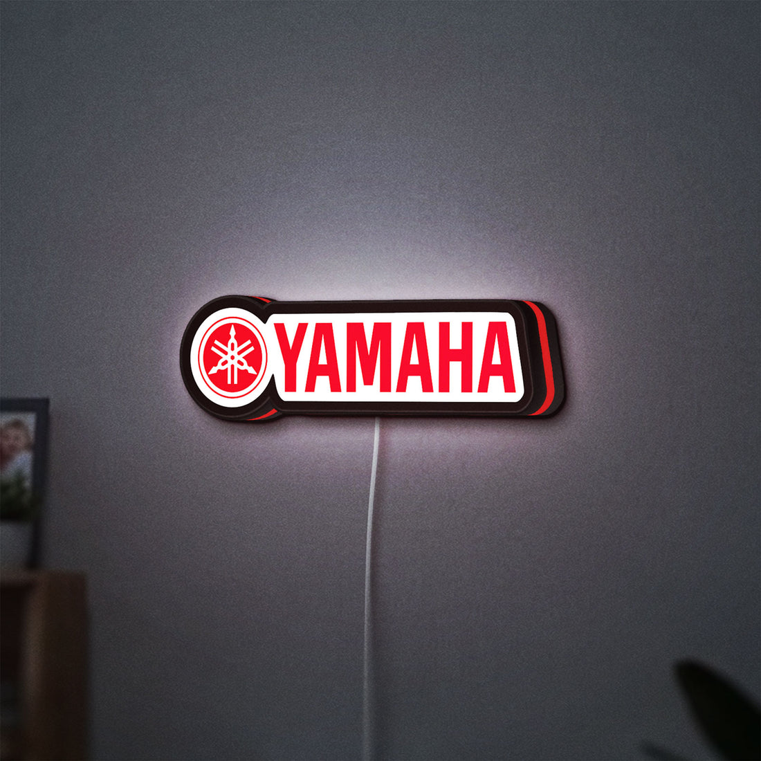 Yamaha LED lightbox hanging on a wall with red glow