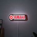 Yamaha LED lightbox hanging on a wall with red glow