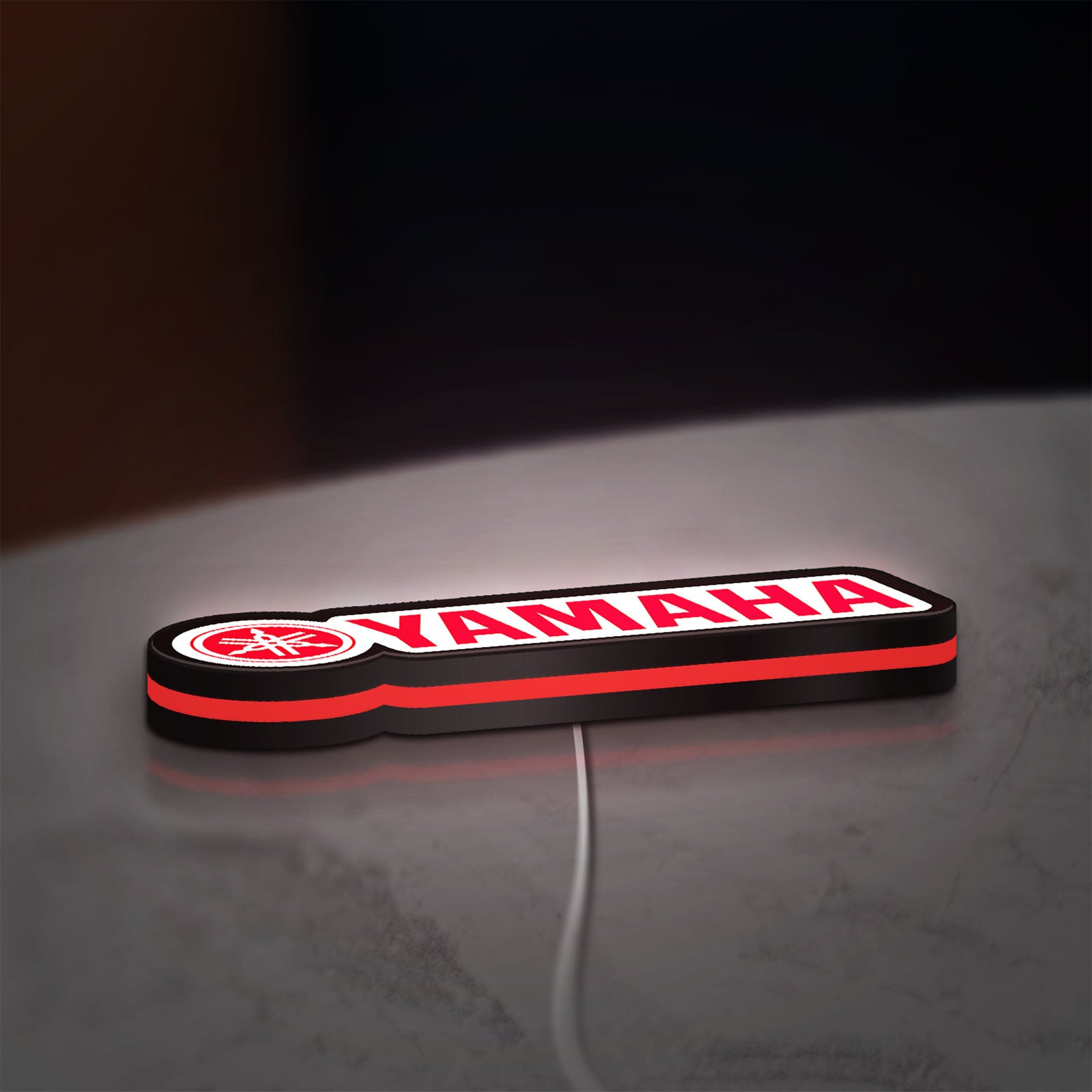 Yamaha LED lightbox lying flat on a desk with red glow