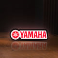 Front view of Yamaha LED lightbox sign glowing on a wooden desk