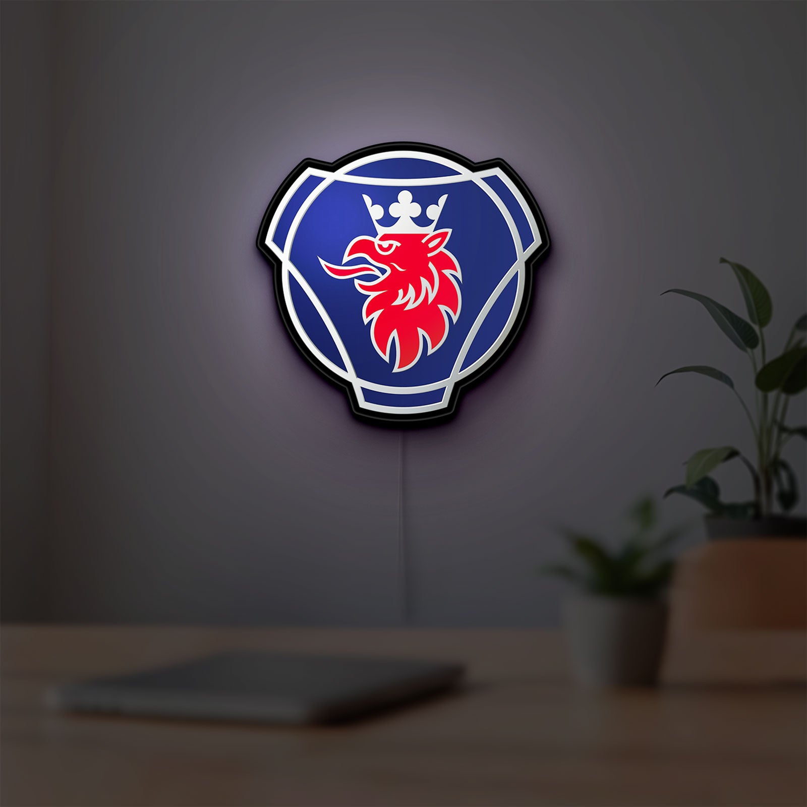 Scania Griffin LED lightbox hanging on a room wall with soft blue light