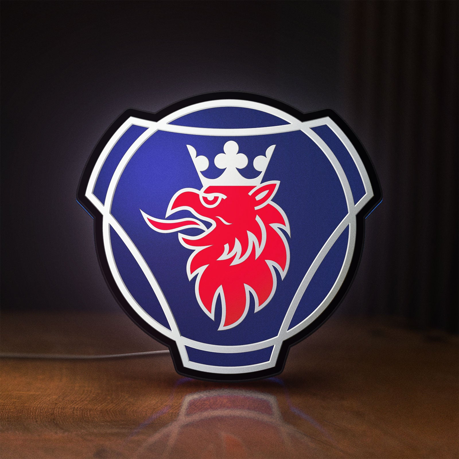 Front view of Scania Griffin LED lightbox sign glowing on a wooden desk