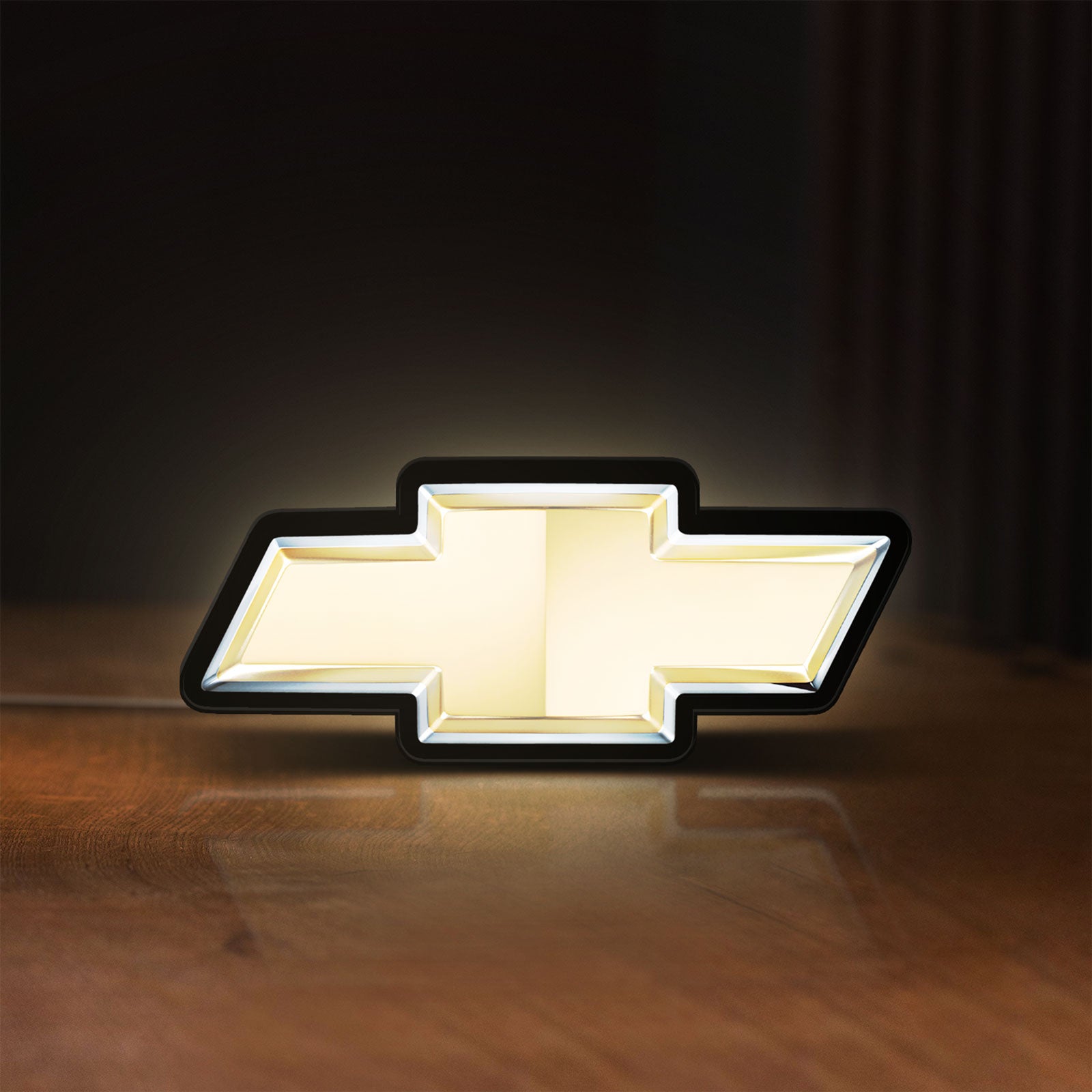 Front view of Chevrolet LED lightbox sign glowing on a wooden desk