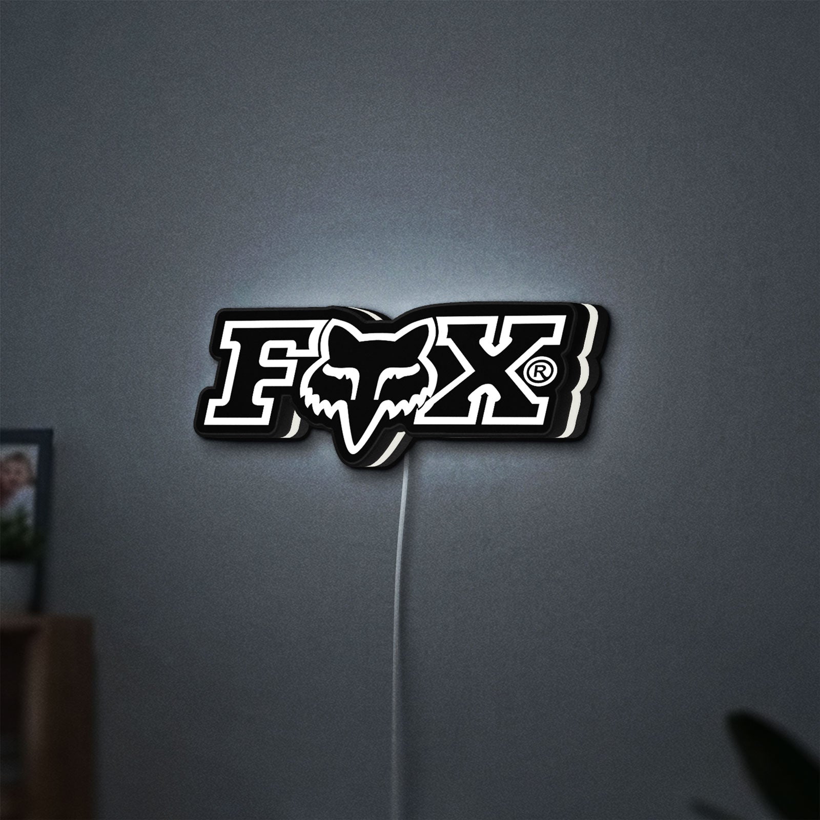 Fox Logo LED lightbox hanging on a wall with white glow