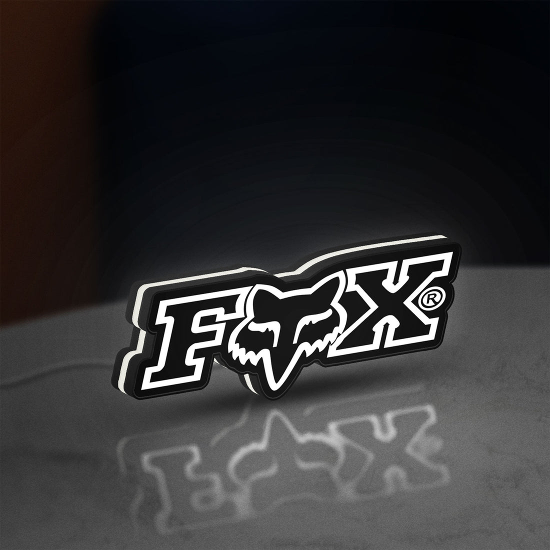 Fox Logo LED lightbox hanging on a wall with white glow