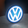 Volkswagen LED lightbox standing on a desk from an angled side view with blue glow