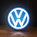 Front view of Volkswagen LED lightbox sign glowing on a wooden desk