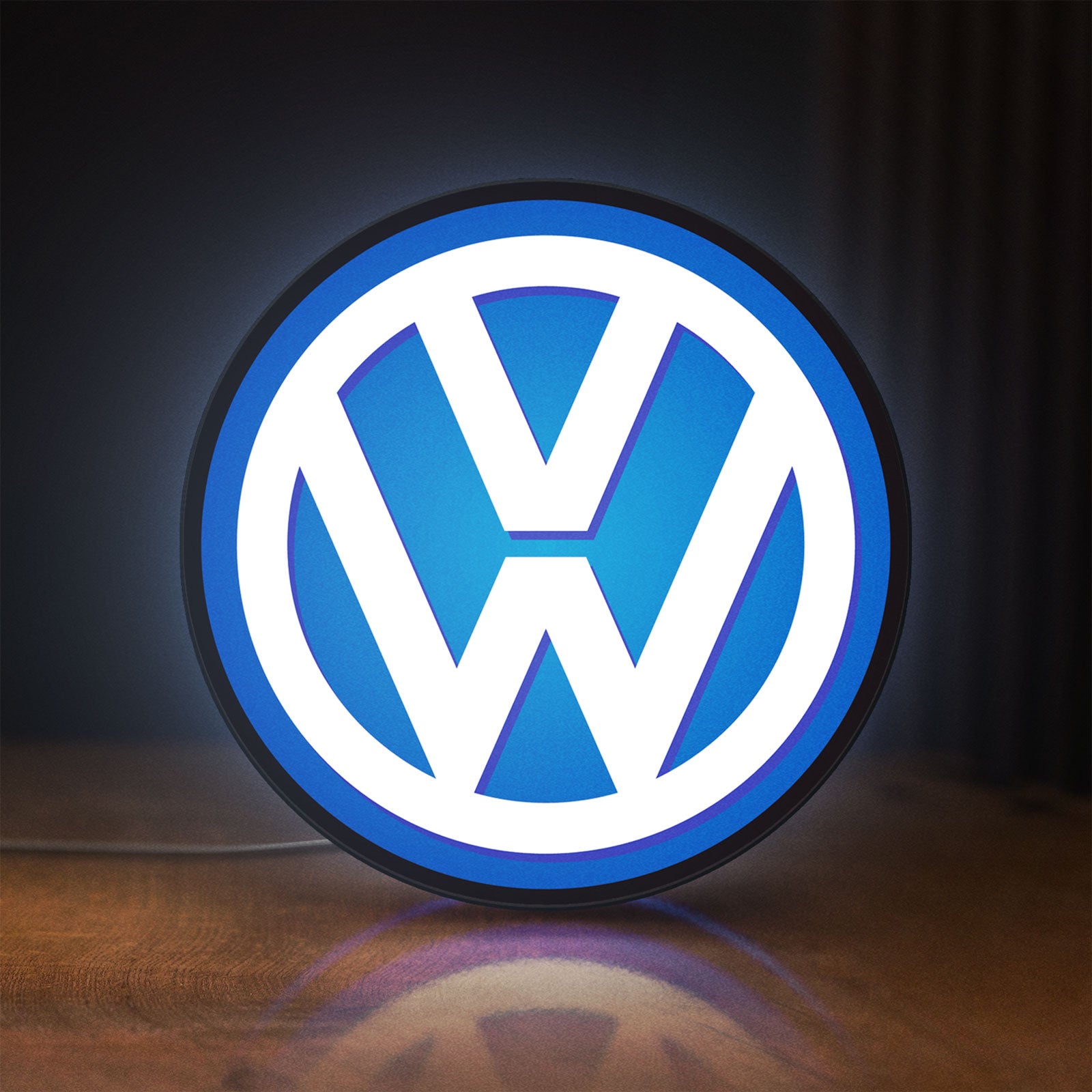 Front view of Volkswagen LED lightbox sign glowing on a wooden desk