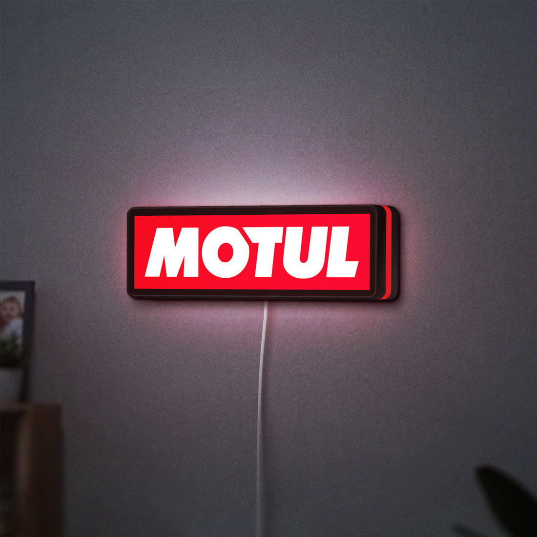 Motul LED lightbox hanging on a wall with red glow