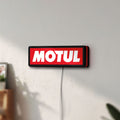 Unlit Motul LED lightbox mounted on a wall in daylight