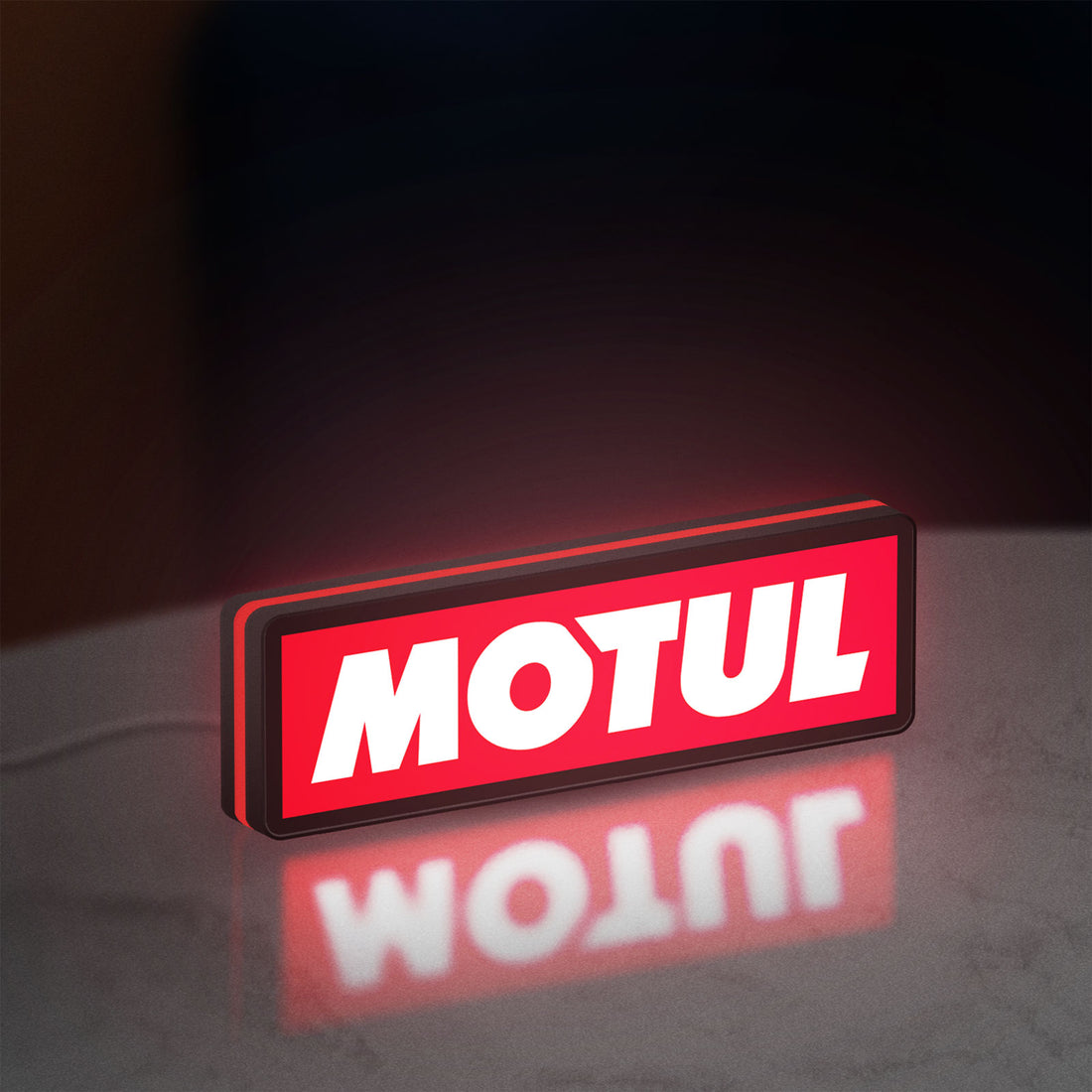 Motul LED lightbox hanging on a wall with red glow