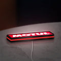 Motul LED lightbox lying flat on a desk with red glow