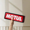 Unlit Motul LED lightbox held by hand to show size and details