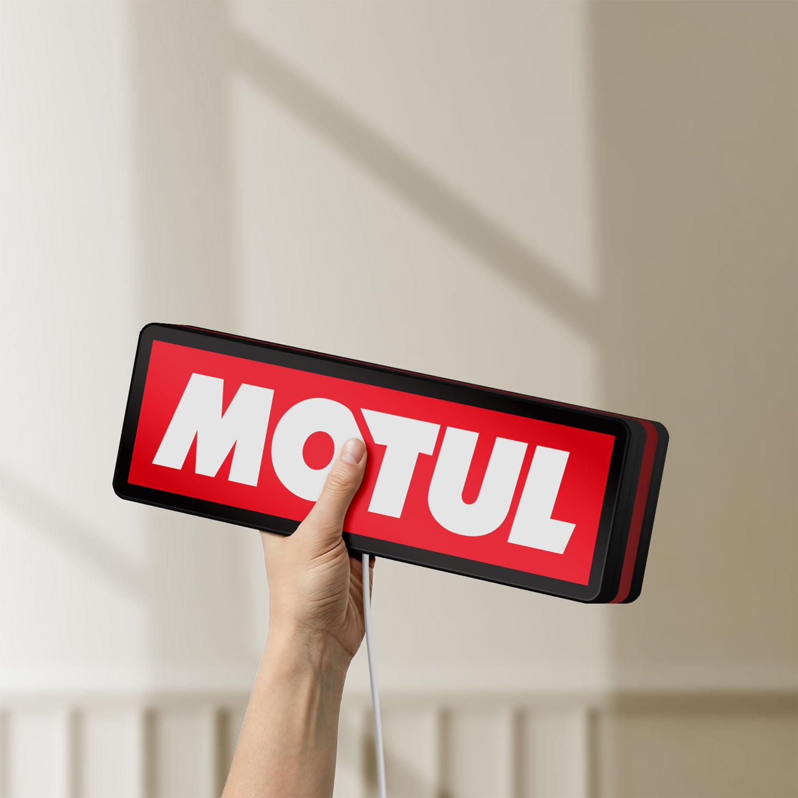 Unlit Motul LED lightbox held by hand to show size and details