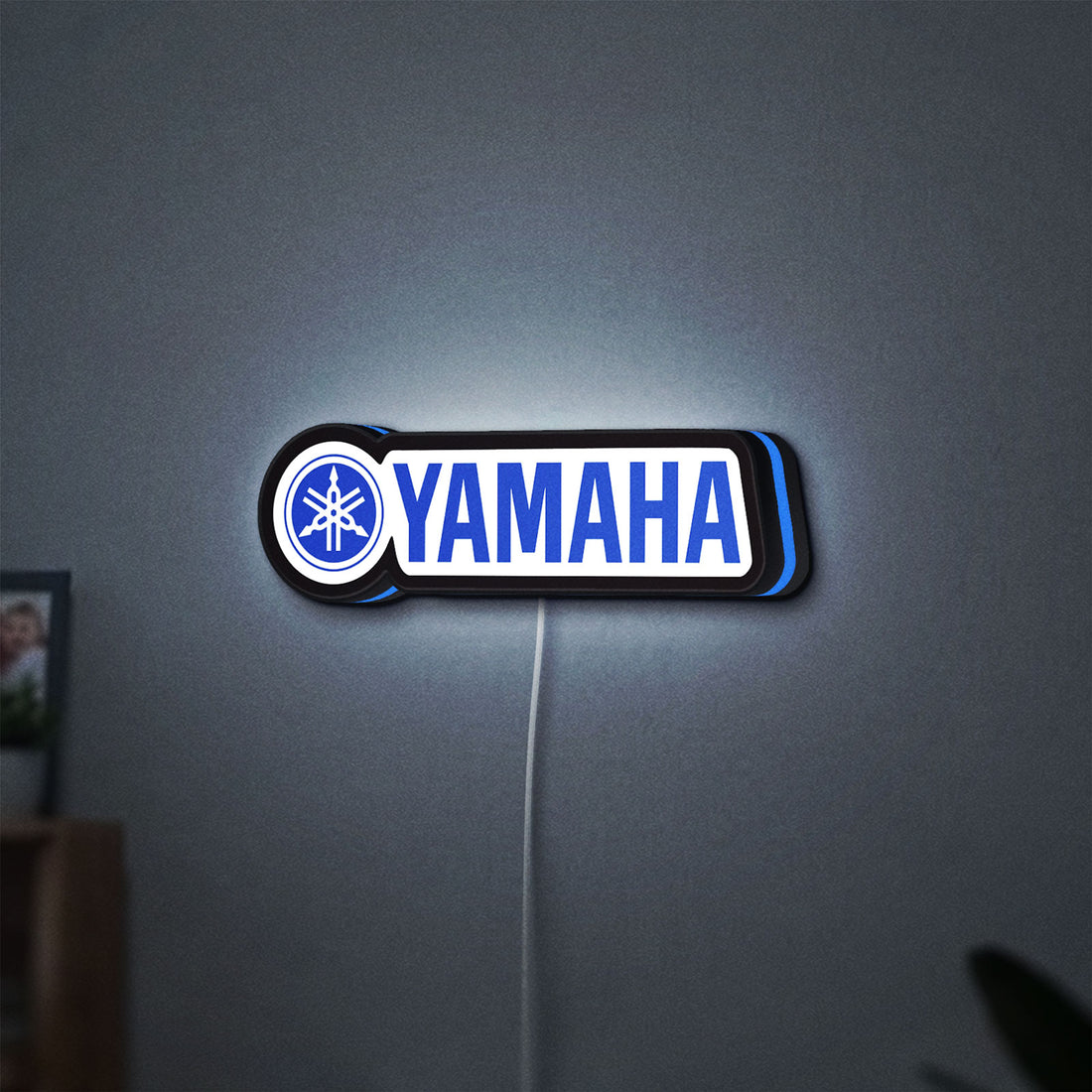 Yamaha LED lightbox hanging on a wall with blue glow