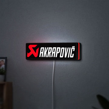 Akrapovic LED lightbox hanging on a wall with red glow