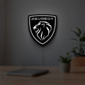 Peugeot Lion Head LED lightbox hanging on a room wall with soft white light