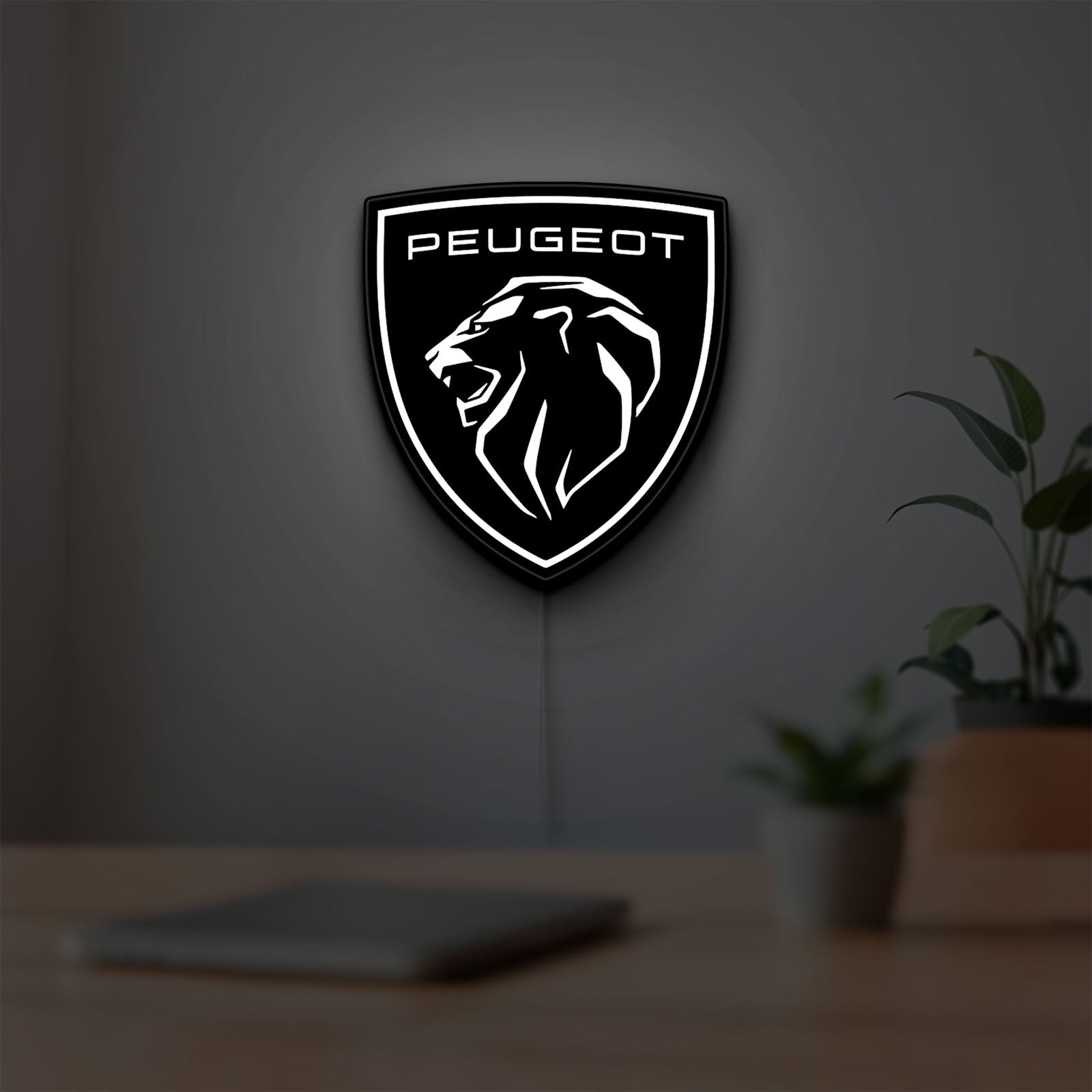 Peugeot Lion Head LED lightbox hanging on a room wall with soft white light