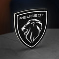 Peugeot Lion Head LED lightbox standing on a desk from an angled side view with white glow