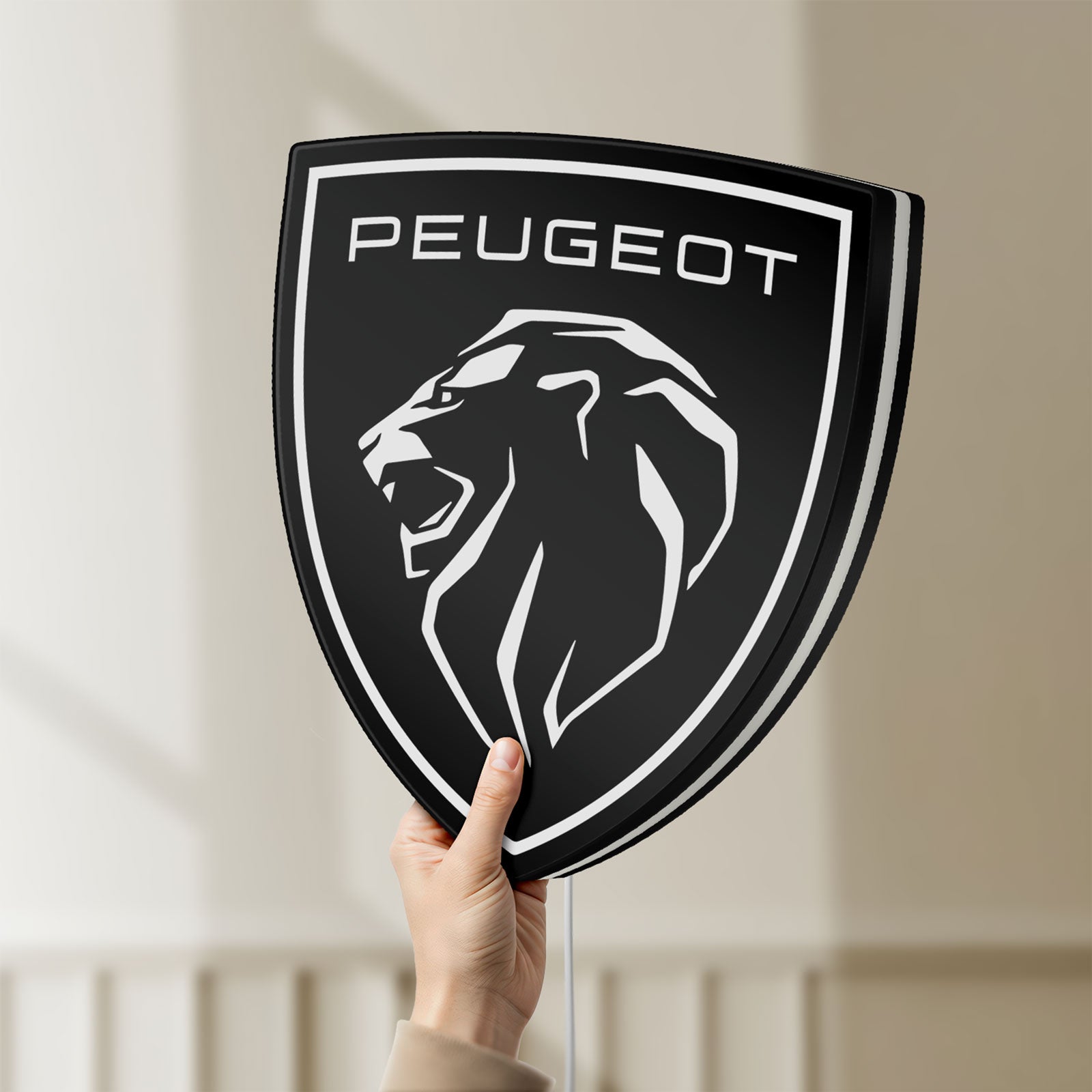 Unlit Peugeot Lion Head LED lightbox held by hand to show size and details