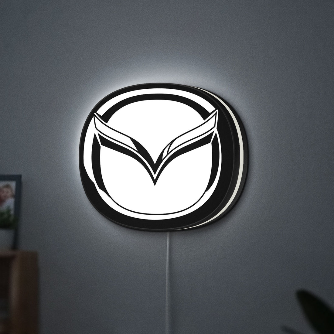 Mazda LED lightbox hanging on a wall with white glow