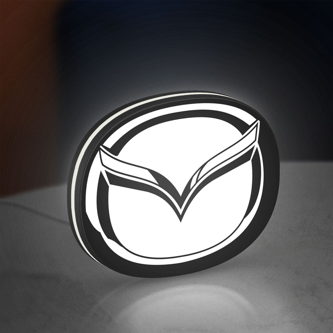 Mazda LED lightbox hanging on a wall with white glow