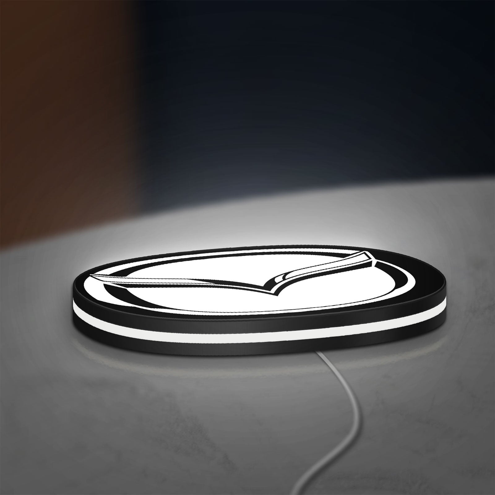 Mazda LED lightbox lying flat on a desk with white glow