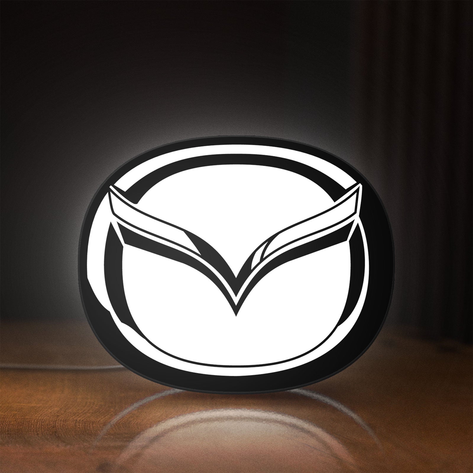 Front view of Mazda LED lightbox sign glowing on a wooden desk
