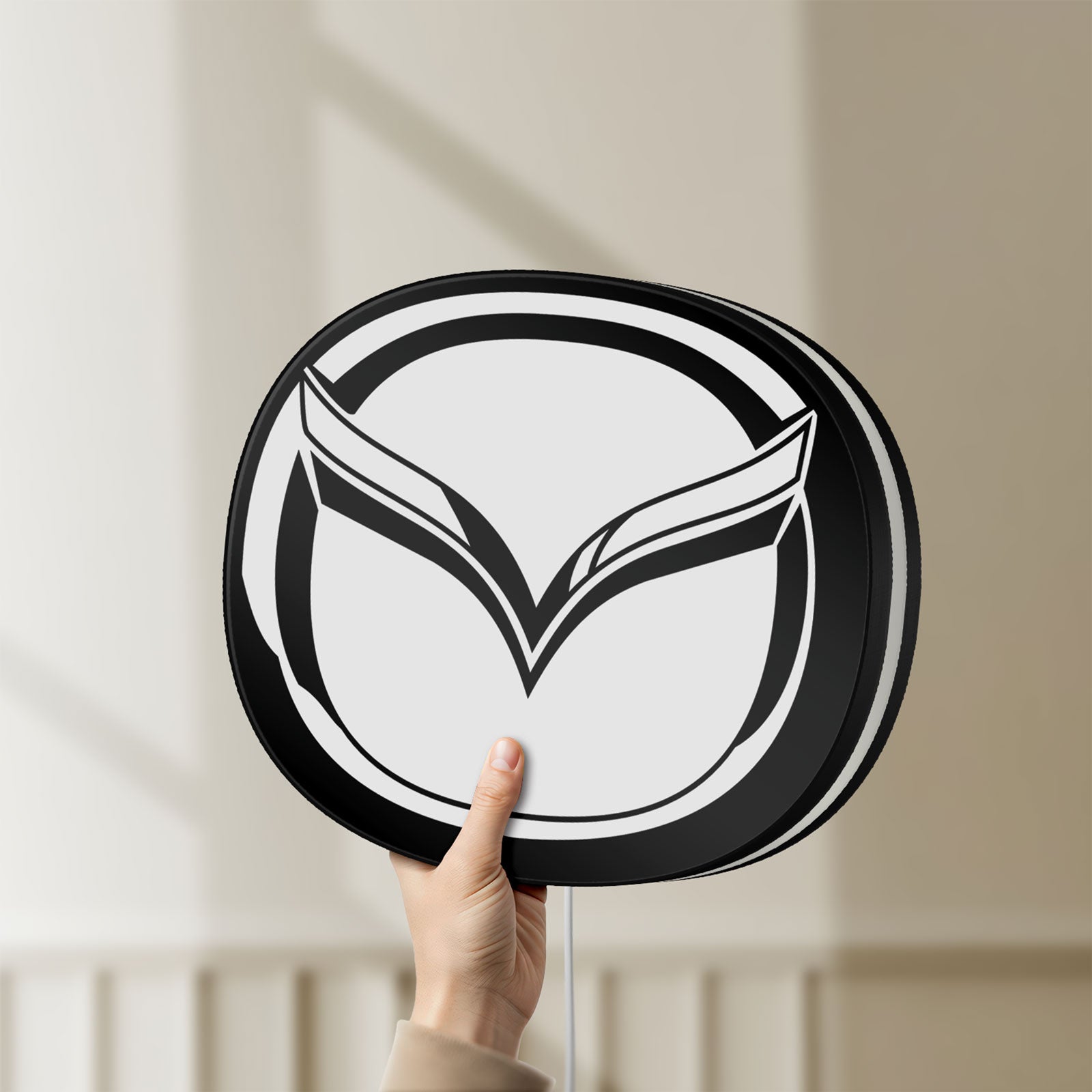 Unlit Mazda LED lightbox held by hand to show size and details