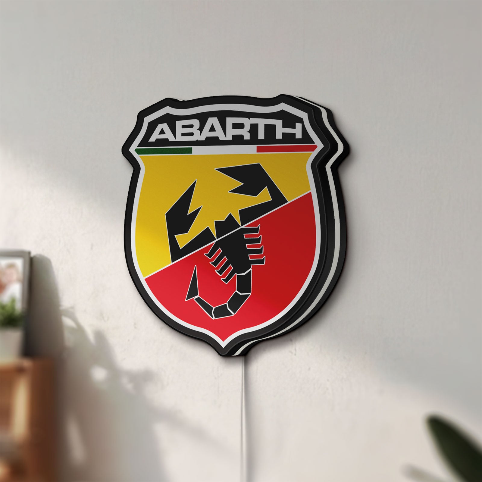 Unlit Abarth LED lightbox mounted on a wall in daylight