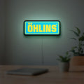 Ohlins LED lightbox hanging on a room wall with soft blue light