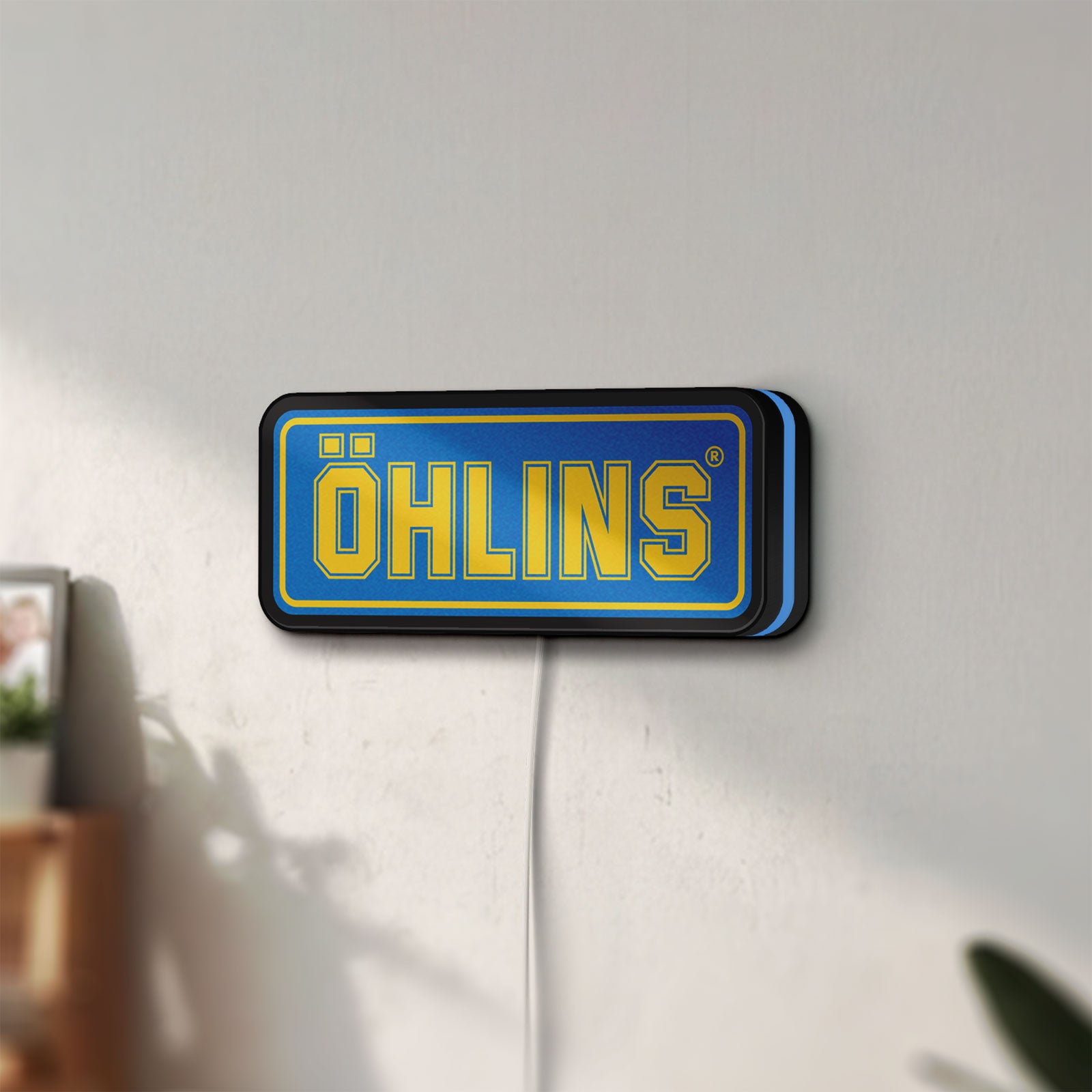 Unlit Ohlins LED lightbox mounted on a wall in daylight
