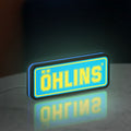Ohlins LED lightbox standing on a desk from an angled side view with blue glow