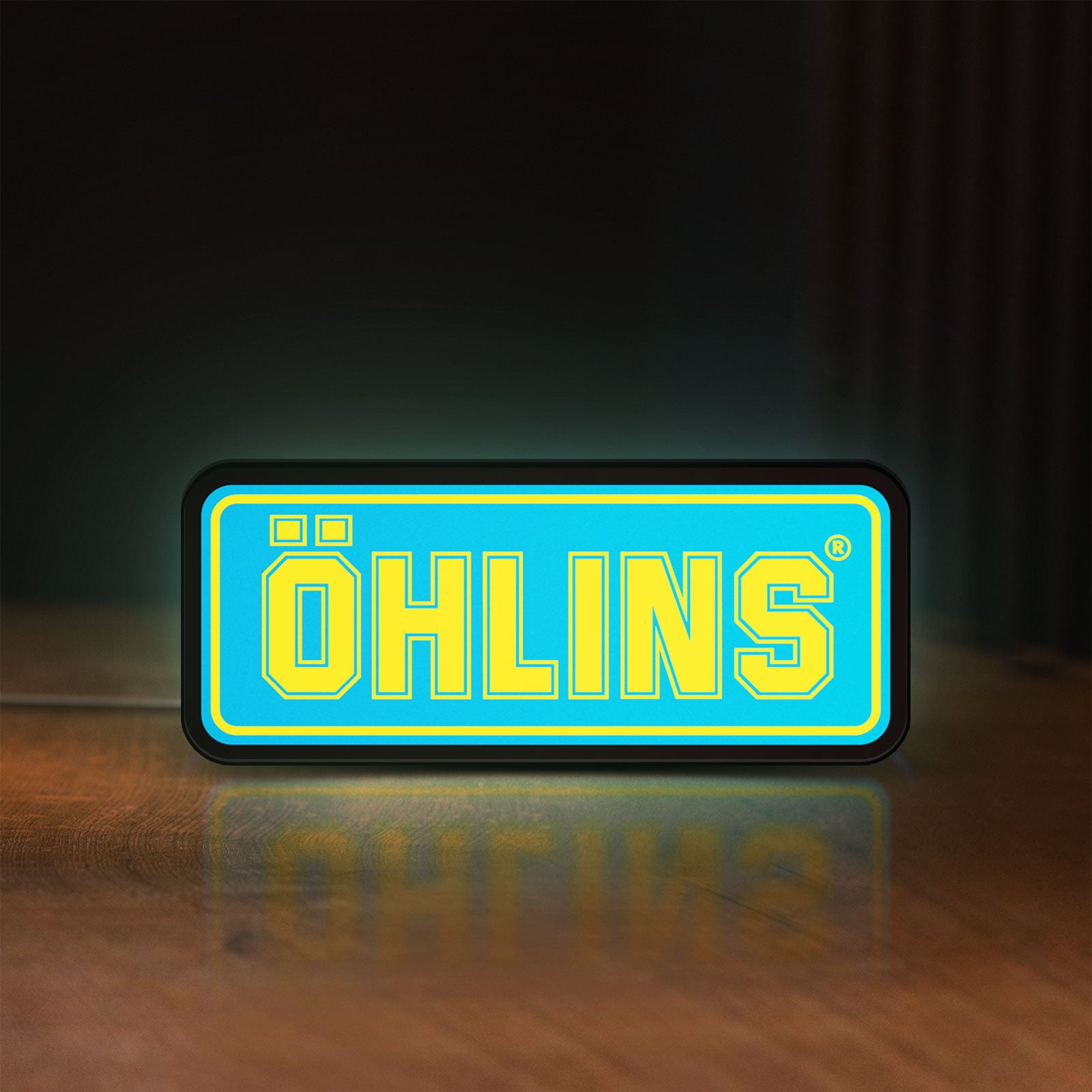 Front view of Ohlins LED lightbox sign glowing on a wooden desk