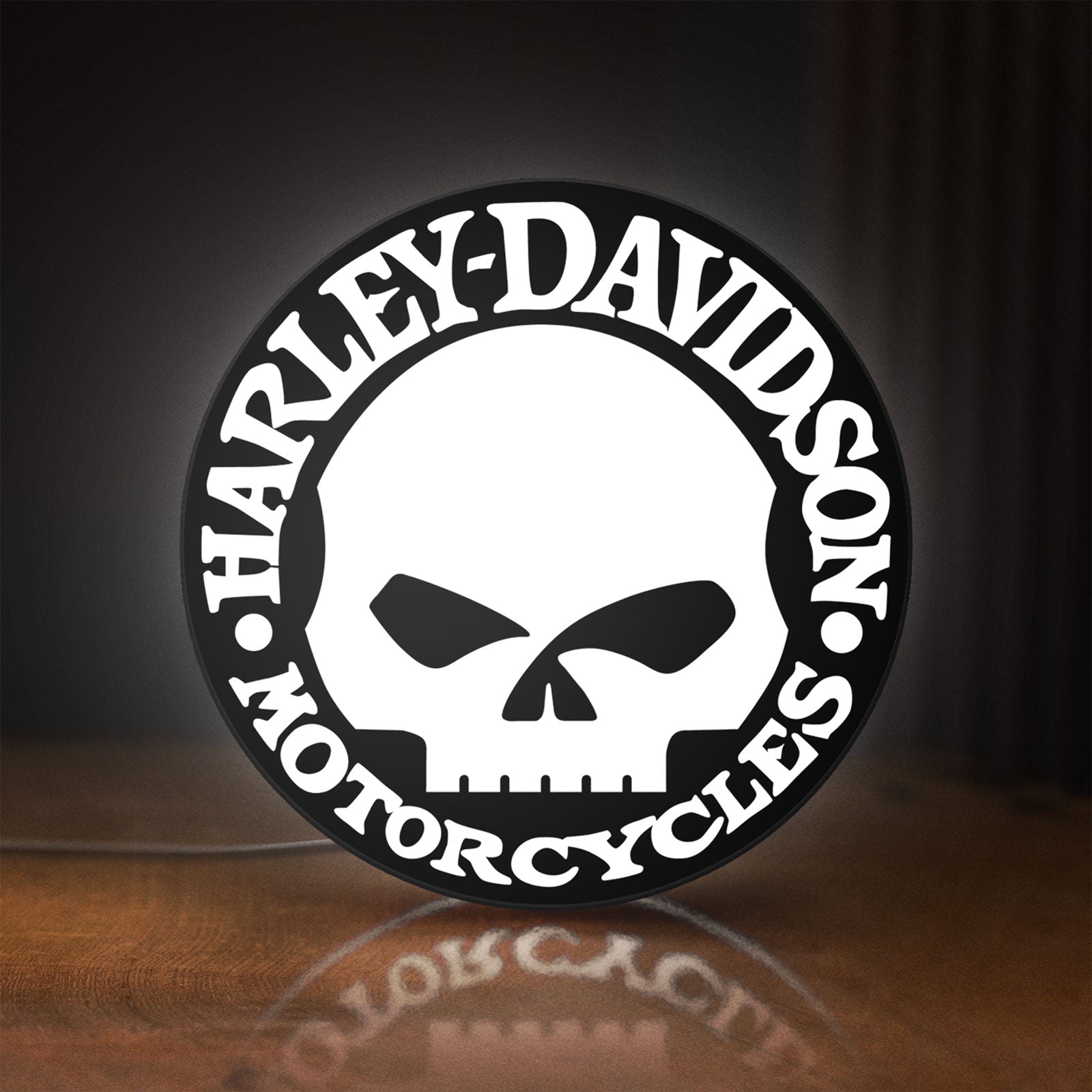 Front view of Harley Davidson Skull LED lightbox sign glowing on a wooden desk