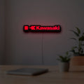 Kawasaki LED lightbox hanging on a room wall with soft red light