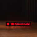 Front view of Kawasaki LED lightbox sign glowing on a wooden desk