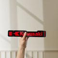 Unlit Kawasaki LED lightbox held by hand to show size and details