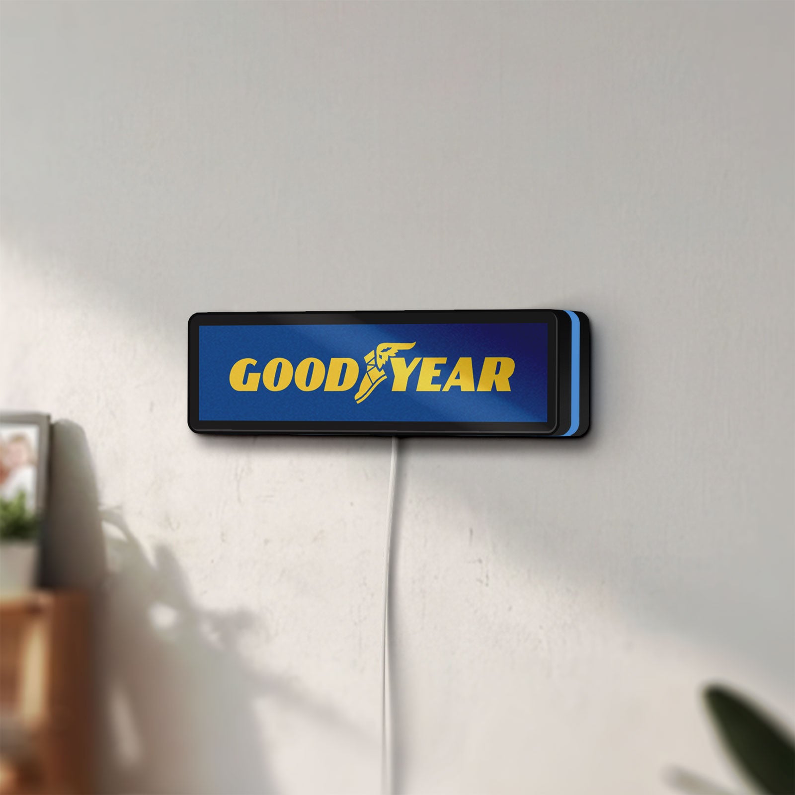 Unlit Goodyear LED lightbox mounted on a wall in daylight