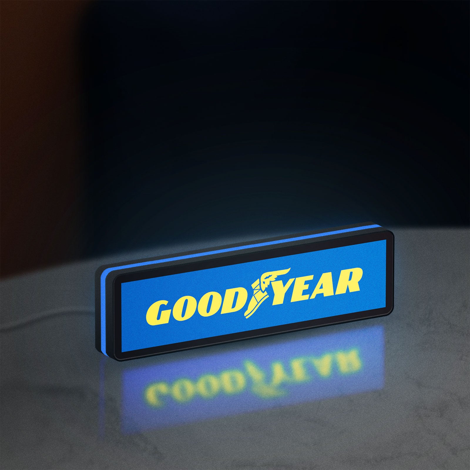 Goodyear LED lightbox standing on a desk from an angled side view with blue glow